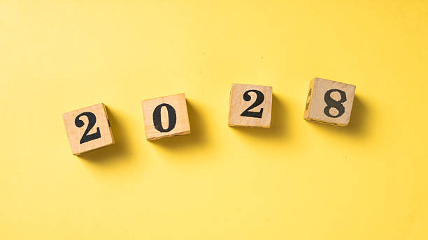 istock Wooden blocks with black numbers forming 2028 arranged in a row on a solid bright yellow background. Symbolizing future year, new beginnings, or goal setting 2223192185