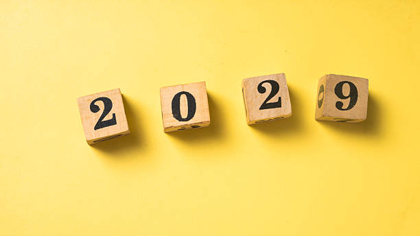 istock Wooden blocks with black numbers forming 2029 arranged in a row on a solid bright yellow background. Symbolizing future year, new beginnings, or goal setting 2223192268