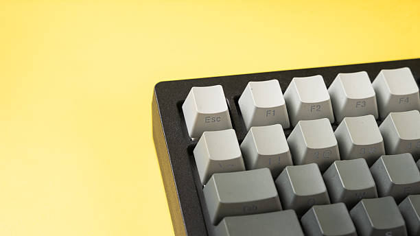 istock Minimalist mechanical keyboard with gradient gray keycaps placed on a vibrant yellow background, showcasing a clean, modern, and top-down tech aesthetic 2223192493