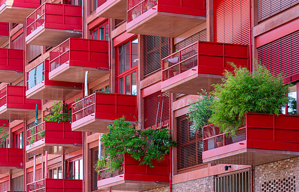 istock Red apartment building with balconies and green plants 2223193472