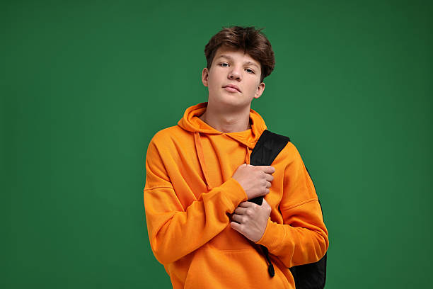 istock Teenage boy with backpack on green background 2223205109