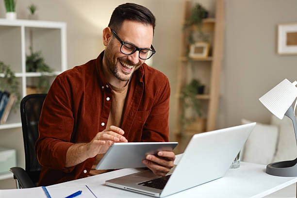 istock Happy businessman working from home using laptop and digital tablet 2223207572
