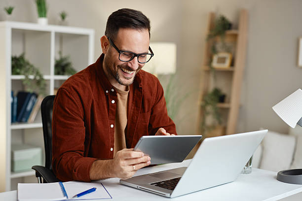 istock Happy entrepreneur working from home using laptop and tablet smiling 2223207852