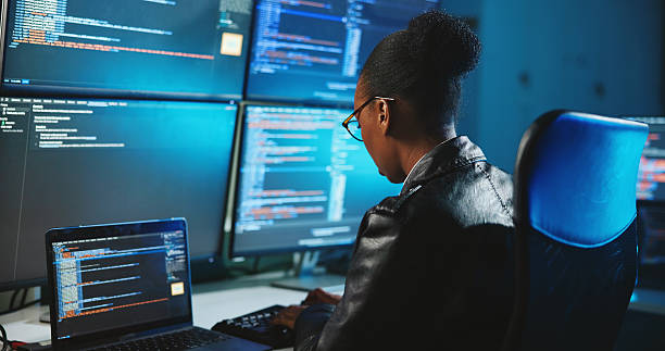istock Hacker, online and woman with computer, night and data for cyber espionage, system and phishing in office. Screen, typing and black person with tech for ransomware, spy and hacking for fraud or scam 2223208552