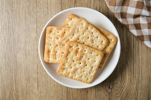 istock Cracker in a white  plate on wooden background table 2223208613