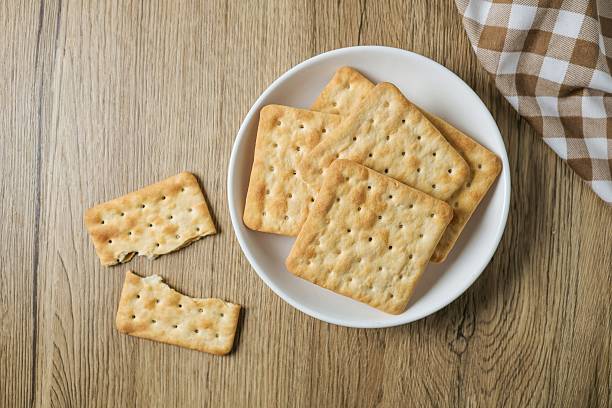 istock Cracker in a white  plate on wooden background table 2223208620