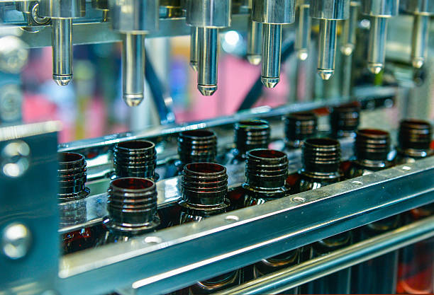 Glass bottles in a conveyor belt on a high quality automatic vertical filling machine stock photo