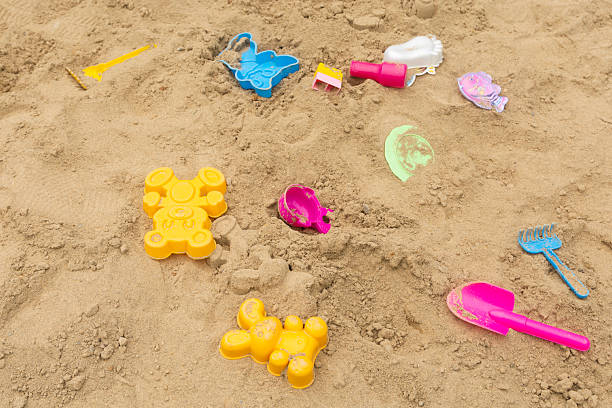Abandoned old toys on a playground with sand. Top view.