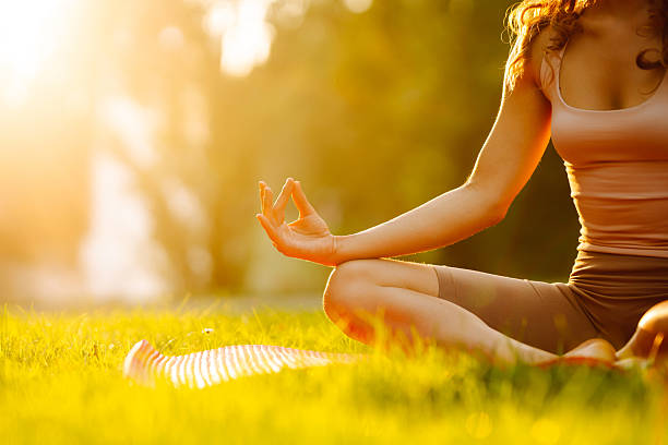 istock Young woman meditating on mat in sunny park. 2223216015