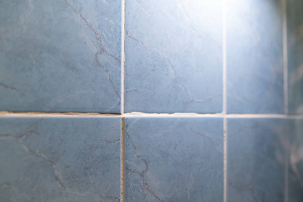 Unevenly laid tiles revealed by flashlight in a room