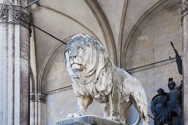 A beautifully carved stone relief depicting a heraldic lion holding a sword, set against a textured and weathered background.