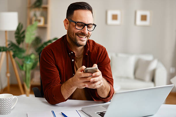 istock Happy entrepreneur using smartphone and laptop at home office 2223217048