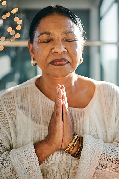 istock Calm Middle-Aged Woman Meditating with Hands Clasped 2223217273