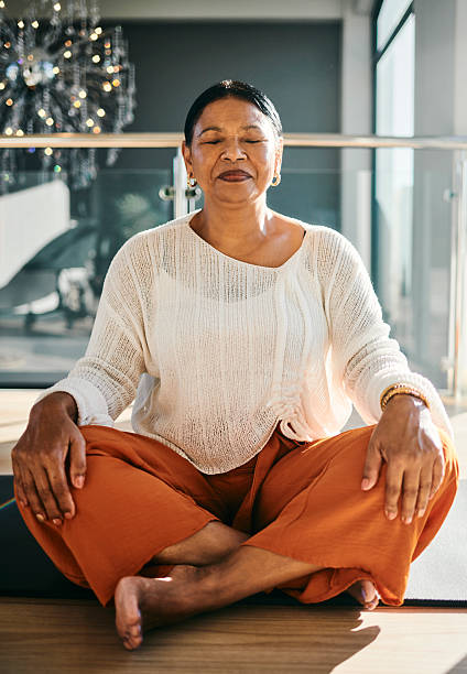 istock Serene Elderly Woman Meditating in Sunlit Room 2223217275