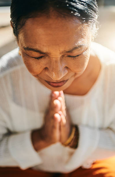 istock Serene Middle-Aged Woman Meditating in Sunlit Room 2223217303