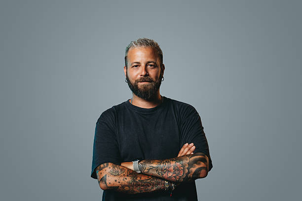 istock Tattooed man with crossed arms looking at camera 2223218501