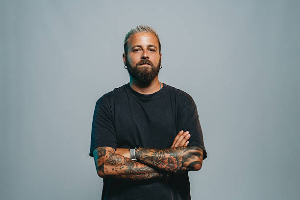 istock Tattooed man with crossed arms looking at camera 2223218525