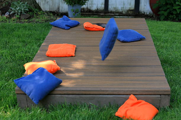istock Blue cornhole bag in midair, about to join orange bags on a cornhole board 2223219203