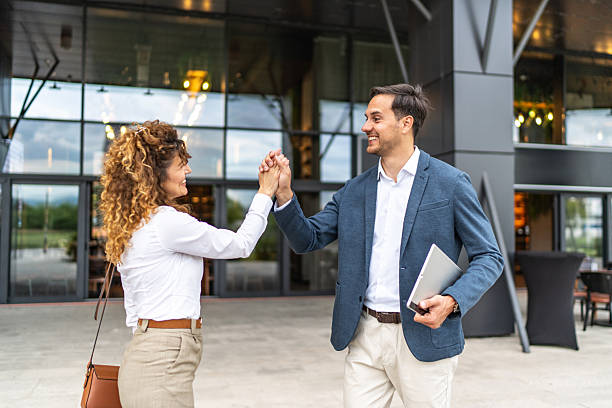 istock Business partners shaking hands in front of modern office building 2223220194