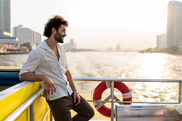 istock Man admiring Chao Phraya river cityscape from boat 2223220419