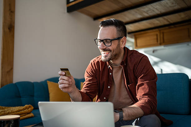 istock Happy man making online payment using credit card and laptop 2223222244