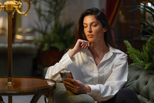 istock Serious woman using mobile phone in hotel lobby 2223222635