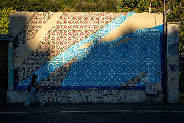 Young female street artist draws graffiti using colorful sprays