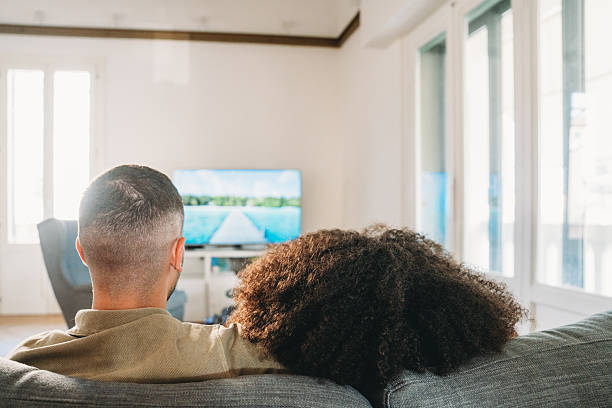 Couple relaxing on sofa watching television at home