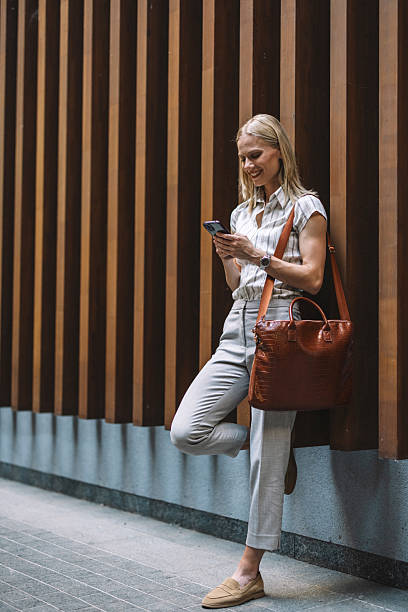 istock Businesswoman Smiling While Messaging on Mobile 2223228898