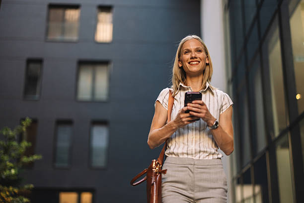 Smiling Woman Texting While Walking Outdoors