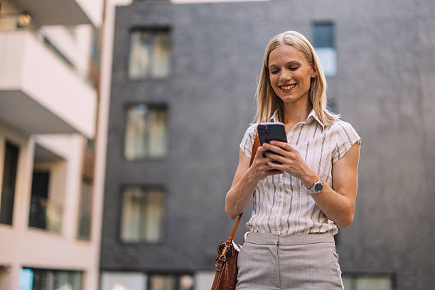 istock Smiling Woman Using Phone in Urban Setting Outdoors 2223229442
