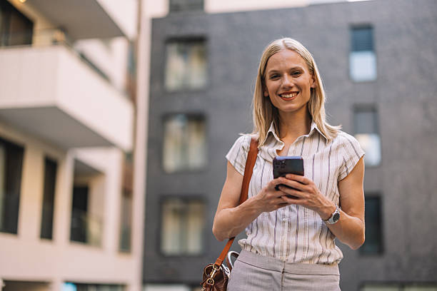 istock Confident Woman Holding Phone and Smiling Brightly 2223229462