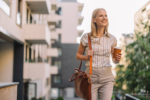 istock Happy woman carrying a bag while enjoying coffee 2223229855