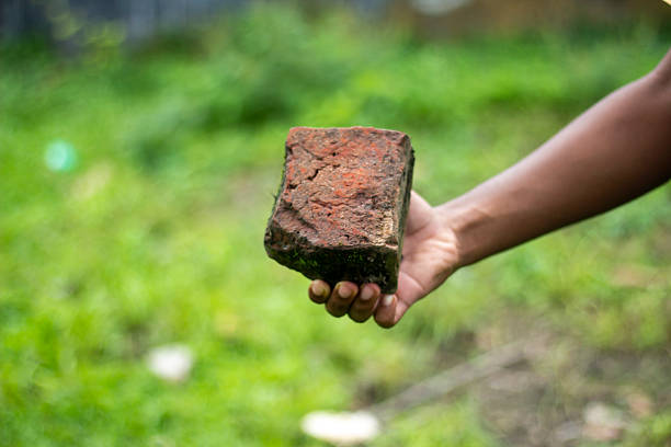A Bricklayer repairs a wall on a domestic property in the UK