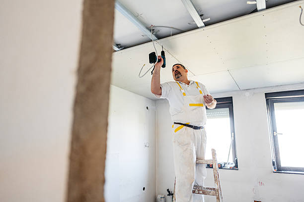 istock Mature Worker Installing Drywall With A Drill On The Ceiling In An Empty Apartment Under Renovation 2223230547