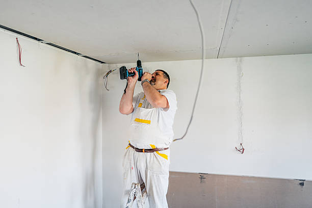 istock Mature Worker Installing Drywall With A Drill On The Ceiling In An Empty Apartment Under Renovation 2223230555