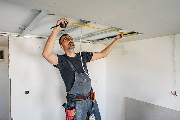 istock Mature Worker Measuring With A Meter Before Installing Drywall On The Ceiling In An Empty Apartment Under Renovation 2223231062