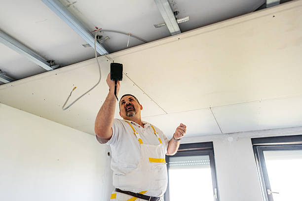 istock Mature Worker Installing Drywall With A Drill On The Ceiling In An Empty Apartment Under Renovation 2223231124