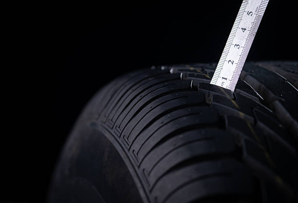 Close-up of winter tire being checked on a black background stock photo