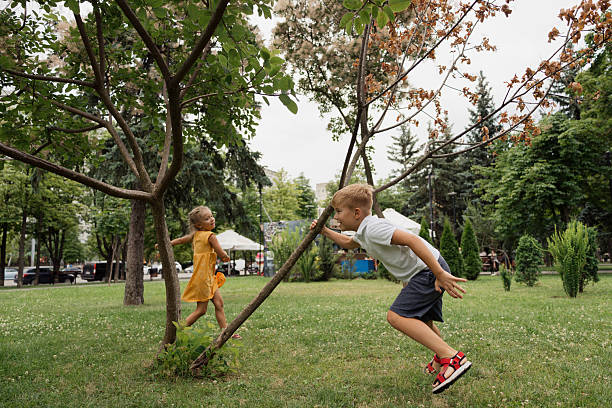Smiling little girl playing hide and seek and counting while other players hiding, children having fun outdoors on playground