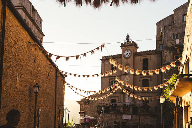 Rustic decorations and clock tower in a traditional Italian square during sunset