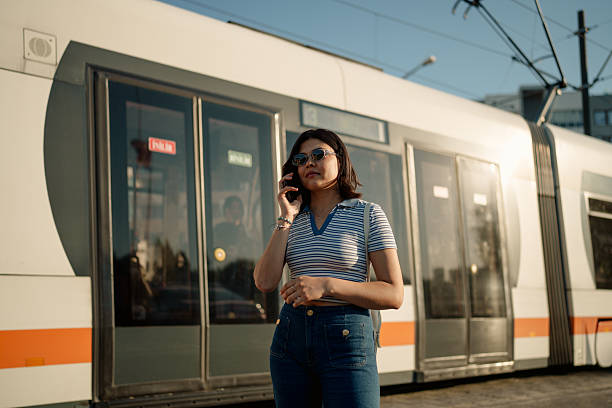 istock Young Woman with Phone at Tram Stop 2223237461