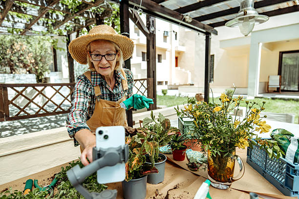istock Casually dressed mature woman vlogging about gardening in backyard 2223237551