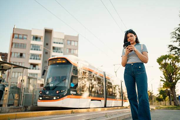istock Young Woman with Phone at Tram Stop 2223237758