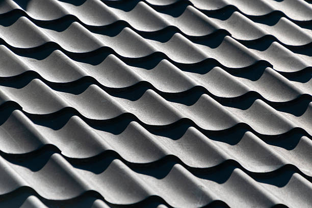 istock Close-up of textured gray wavy tile roof pattern in sunlight 2223238051
