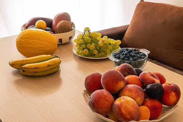 Vibrant fruit arrangement with peaches, bananas, melon, grapes, and blueberries on table