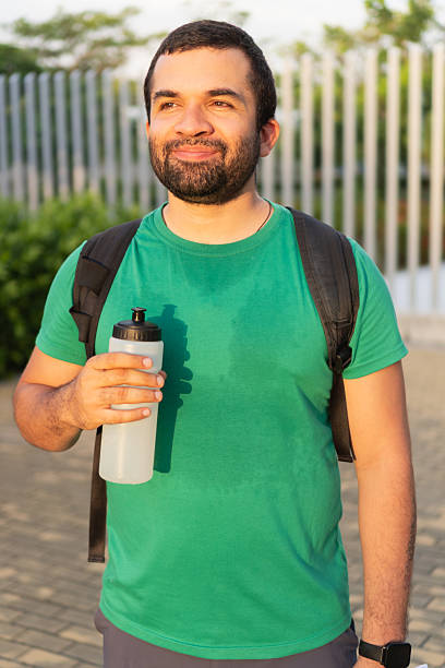 istock Smiling sportsman holding water bottle after training 2223240560