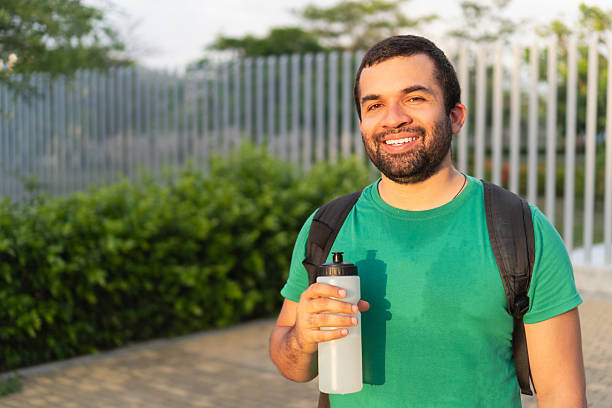 istock Young man rehydrating after workout in a park 2223240574