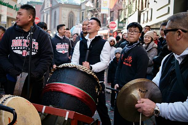 New York, New York, USA- January 29, 2025: A group of percussionists play large drums and cymbals during a lively Lunar New Year parade in Chinatown.