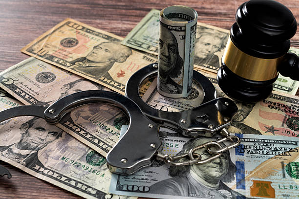 istock Gavel and handcuffs on stack of US paper currency 2223242117